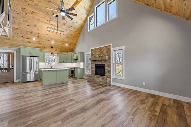 unfurnished living room featuring plenty of natural light, wooden ceiling, a sink, and light wood-style flooring