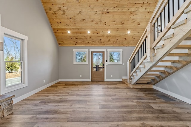 foyer entrance featuring a wealth of natural light, baseboards, and wood finished floors