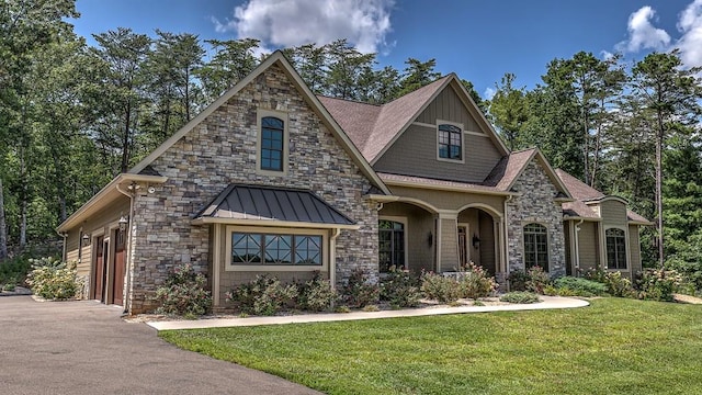 view of front of property with driveway, a standing seam roof, metal roof, and a front yard