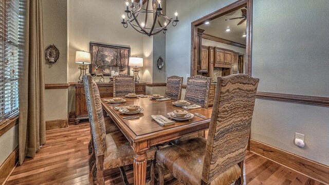 dining area featuring a chandelier, arched walkways, light wood-style flooring, and ornate columns