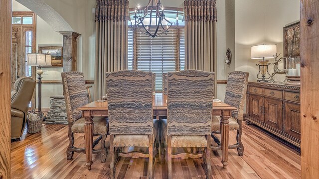 kitchen featuring a kitchen island with sink, ceiling fan with notable chandelier, stainless steel appliances, light stone countertops, and light wood finished floors