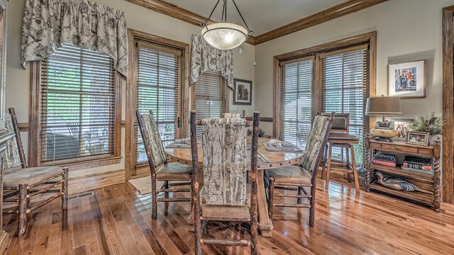 dining room with ornamental molding and light wood-type flooring