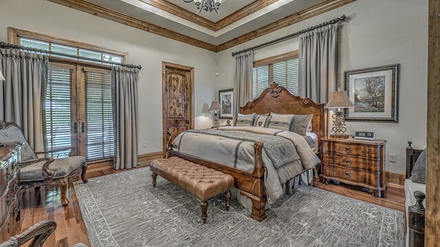 bedroom with ornamental molding, wood finished floors, and baseboards