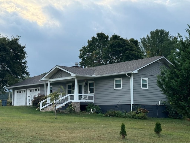 view of front of home with a garage, a front lawn, and covered porch