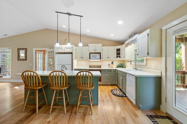 76 Misty River Ln, Hayesville, NC 28904 - kitchen featuring white appliances, lofted ceiling, a kitchen island, light wood-style floors, and light countertops