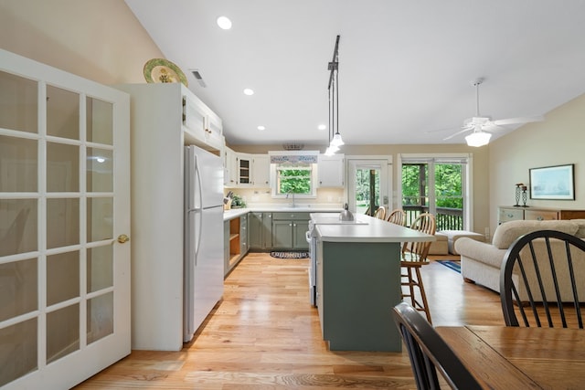 76 Misty River Ln, Hayesville, NC 28904 - kitchen with freestanding refrigerator, a breakfast bar area, light countertops, light wood-style floors, and pendant lighting