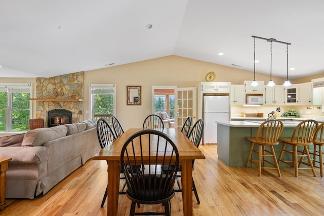 76 Misty River Ln, Hayesville, NC 28904 - dining room featuring vaulted ceiling, light wood finished floors, and a fireplace