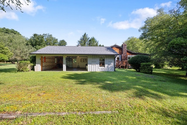 76 Misty River Ln, Hayesville, NC 28904 - rear view of house with a yard, board and batten siding, a chimney, and an outbuilding