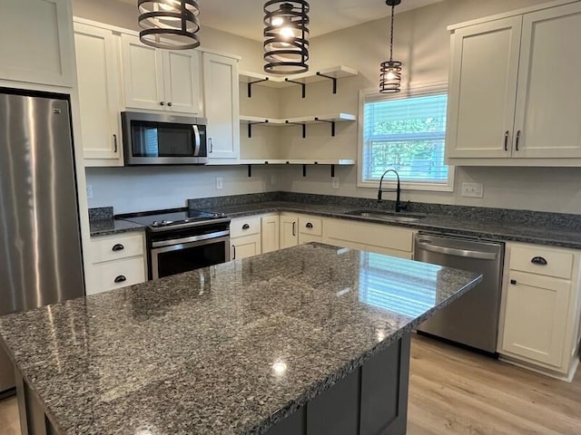 28 Arlington St, Hayesville, NC 28904 - kitchen featuring appliances with stainless steel finishes, light wood-style floors, open shelves, a kitchen island, and dark stone countertops