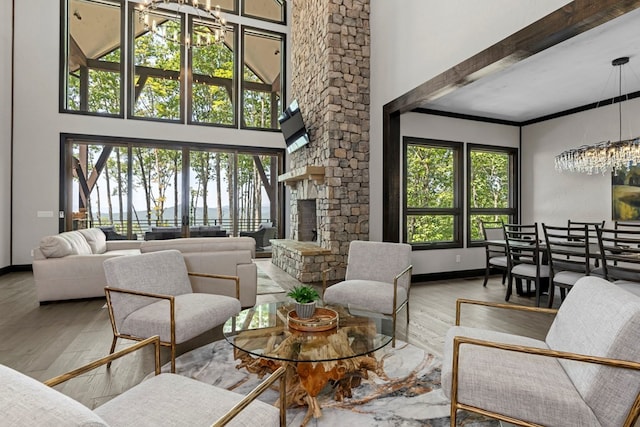 living room featuring a healthy amount of sunlight, a notable chandelier, hardwood / wood-style flooring, and beamed ceiling