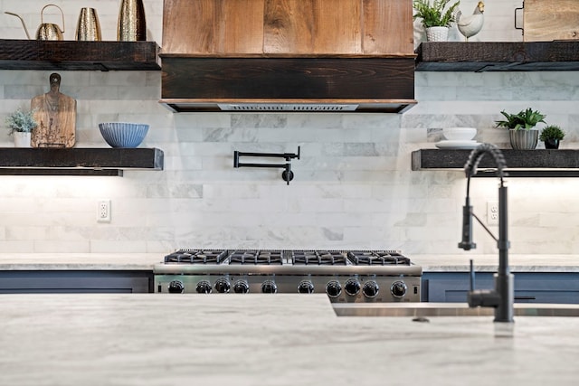 kitchen with stainless steel gas cooktop, decorative backsplash, and exhaust hood