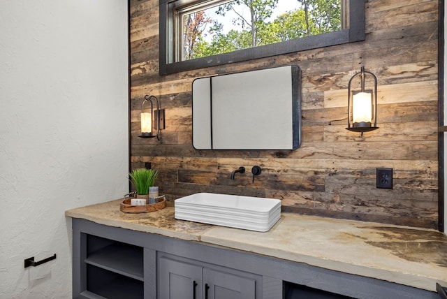 bathroom featuring vanity and wood walls