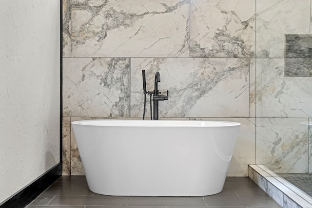 bathroom featuring tile walls and a washtub