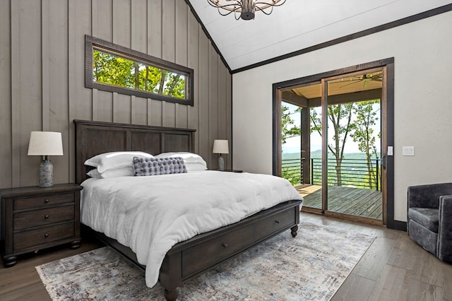 bedroom with wood-type flooring, wood walls, access to outside, and vaulted ceiling