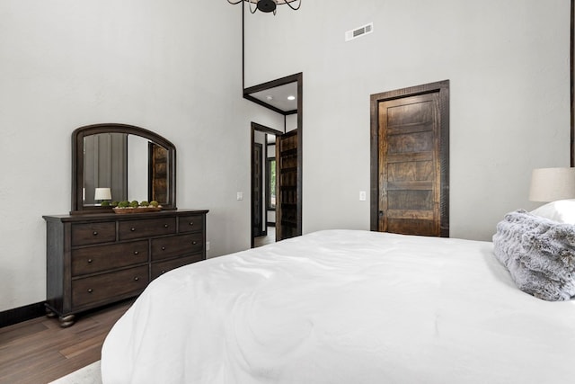 bedroom featuring a high ceiling and dark hardwood / wood-style floors