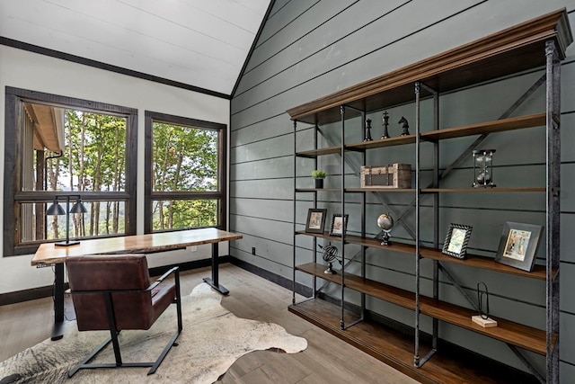 office area with vaulted ceiling, wooden walls, and hardwood / wood-style floors