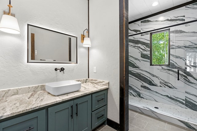 bathroom featuring vanity, tile patterned floors, and tiled shower