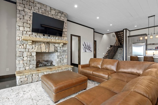 living room featuring a stone fireplace and crown molding