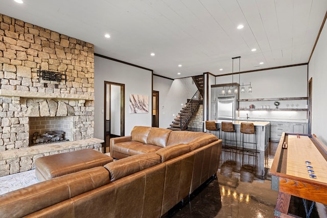 living room featuring crown molding, indoor bar, and a fireplace