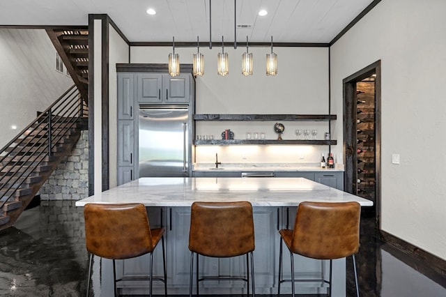 kitchen featuring stainless steel built in fridge, light stone countertops, gray cabinetry, and decorative light fixtures