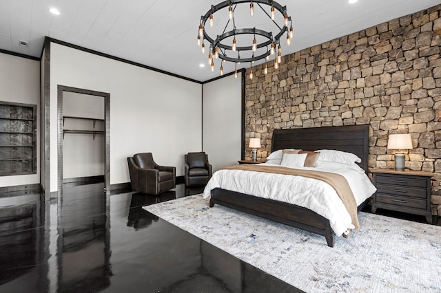 bedroom featuring a spacious closet, ornamental molding, a notable chandelier, and a closet