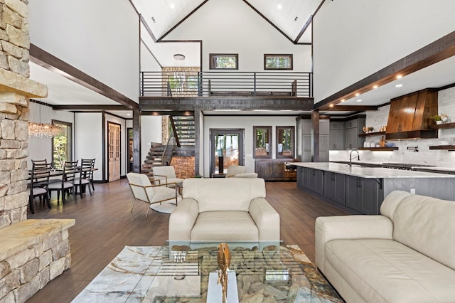 living room featuring beamed ceiling, dark wood-type flooring, sink, a chandelier, and high vaulted ceiling