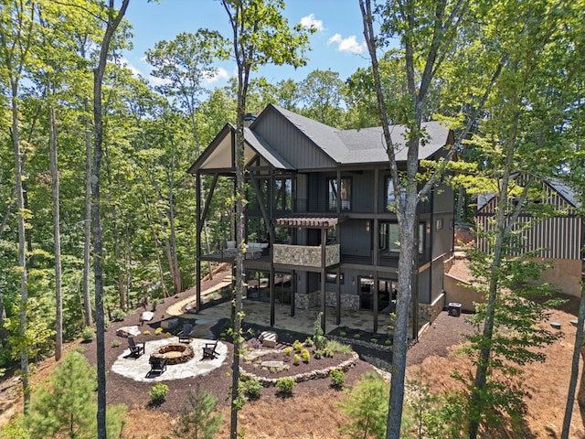 back of property featuring a patio and an outdoor fire pit