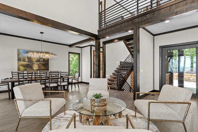 living room featuring a notable chandelier, a healthy amount of sunlight, beamed ceiling, and hardwood / wood-style floors