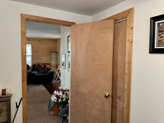 corridor with dark carpet and wooden walls