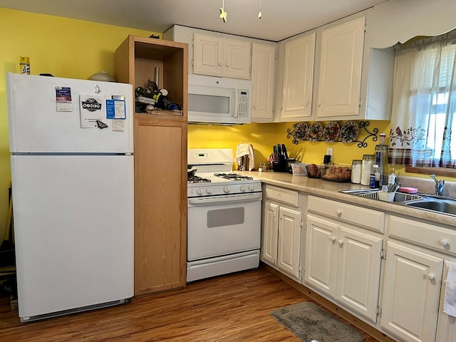 kitchen featuring wood-type flooring, white appliances, white cabinetry, and sink