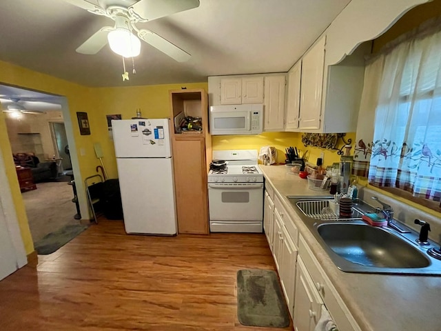 kitchen with white appliances, sink, ceiling fan, light wood-type flooring, and white cabinetry