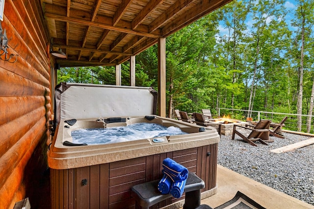 view of patio / terrace with a hot tub and an outdoor fire pit