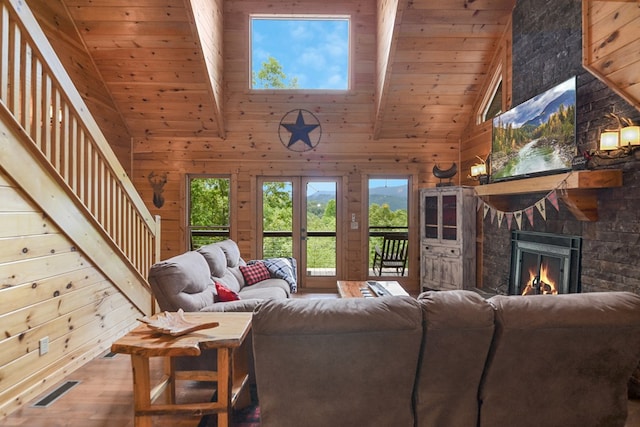 living room with beamed ceiling, wood-type flooring, wooden ceiling, and wooden walls