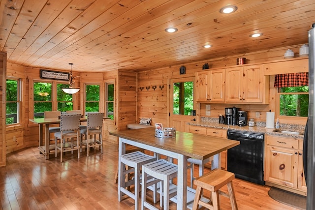 kitchen with pendant lighting, light brown cabinetry, dishwasher, light stone countertops, and light wood-type flooring