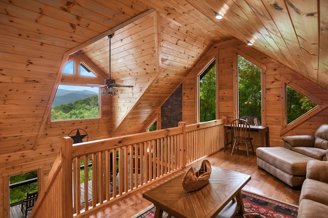 bonus room with a mountain view, wood ceiling, wood-type flooring, and wood walls