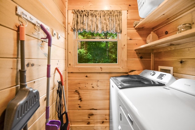 laundry area with separate washer and dryer and wood walls