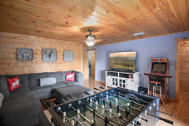 living room featuring ceiling fan, wooden walls, hardwood / wood-style floors, and wooden ceiling