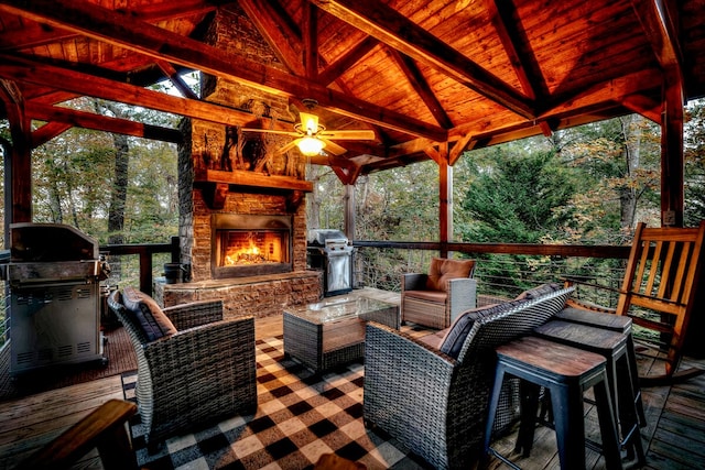 deck with grilling area and an outdoor stone fireplace