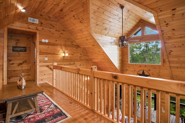 corridor featuring vaulted ceiling, wooden walls, hardwood / wood-style floors, and wooden ceiling