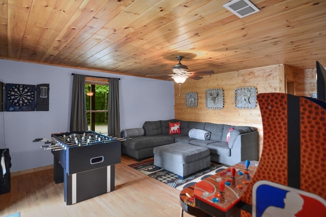 living room with ceiling fan, ornamental molding, wood-type flooring, and wooden ceiling