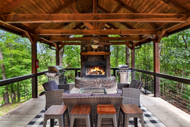 view of patio / terrace featuring a grill, an outdoor living space with a fireplace, and a deck