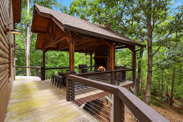 deck with a bar and an outdoor fireplace