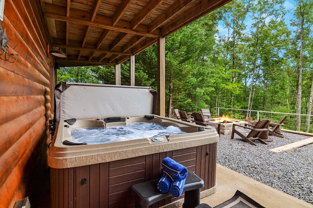 view of patio with a hot tub and an outdoor fire pit