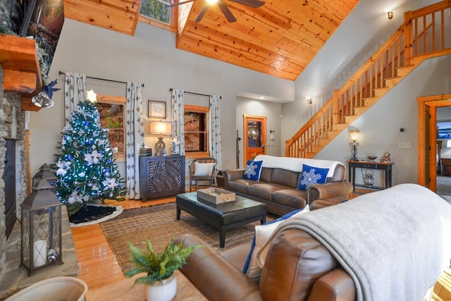 living area featuring high vaulted ceiling, wood finished floors, ceiling fan, stairway, and wood ceiling