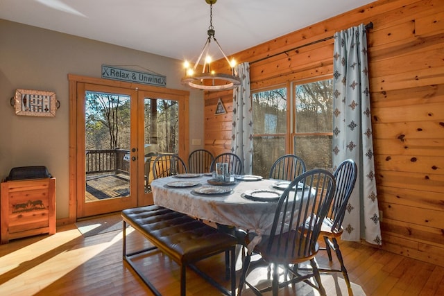 dining space featuring hardwood / wood-style flooring, french doors, and a chandelier