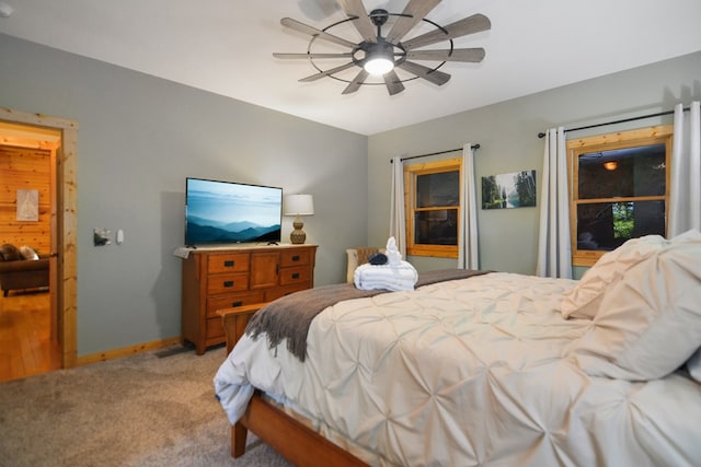 bedroom with light carpet, ceiling fan, and baseboards