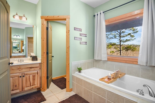 full bathroom with tile patterned floors, a bath, vanity, and baseboards