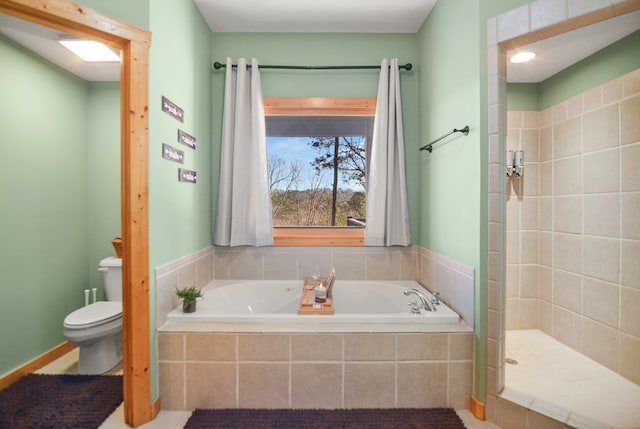 bathroom featuring toilet, a bath, and a stall shower