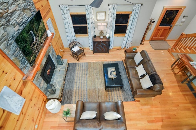 living area featuring wood finished floors and a stone fireplace