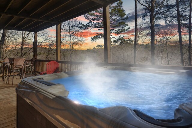 view of swimming pool featuring outdoor dining space, a wooden deck, and a hot tub